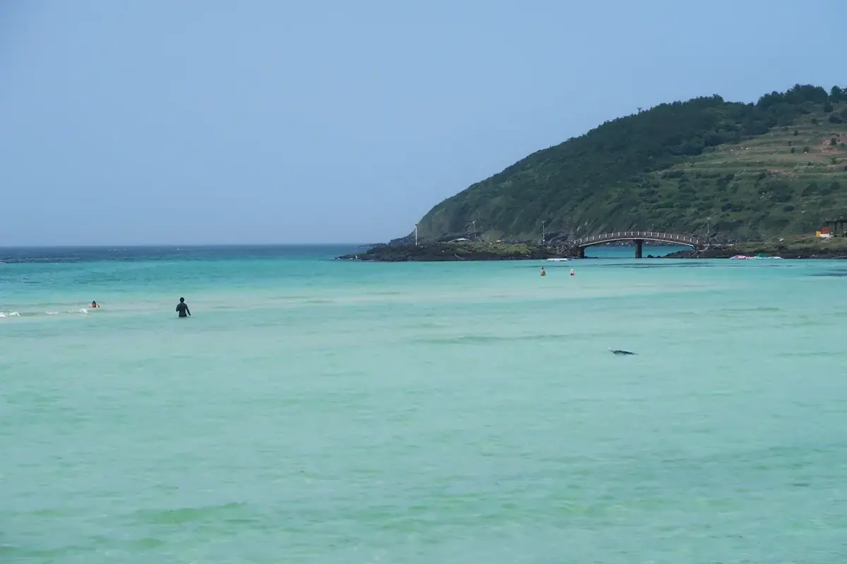 Emerald-colored water at Hamdeok Beach with Seoubong in the background
