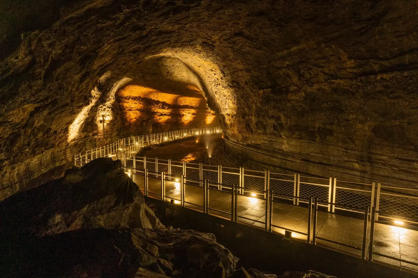 Illuminated walking path inside Manjanggul Lava Tube