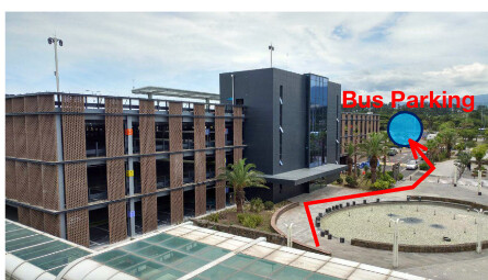 PowerPoint photograph of the parking building with a red arrow showing the route to the bus parking area